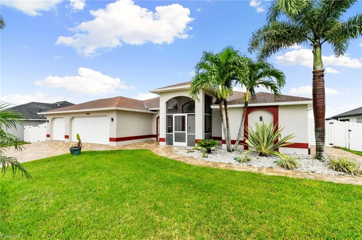 View of front of home with stucco siding, an attached garage, driveway, and a gate