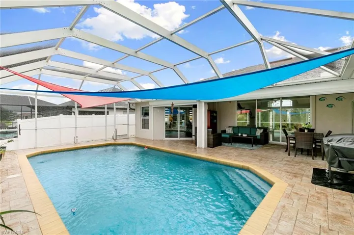 View of swimming pool with an outdoor hangout area, a patio, and glass enclosure