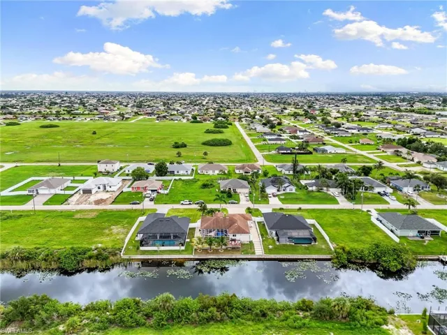 Aerial perspective of suburban area featuring property parcel outlined and a nearby body of water