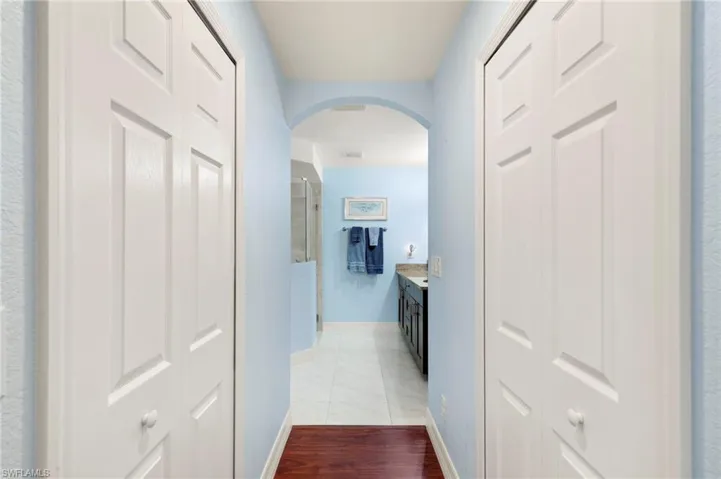 Corridor with arched walkways and wood finished floors