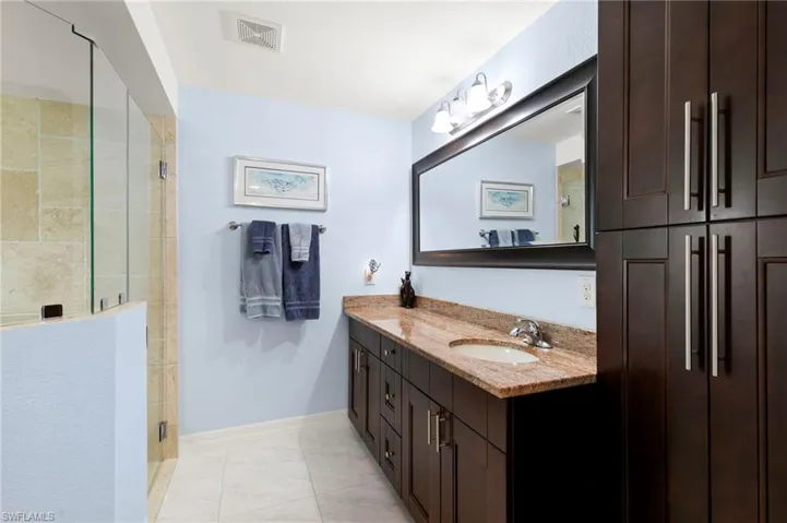 Bathroom with vanity, a shower stall, and tile patterned flooring