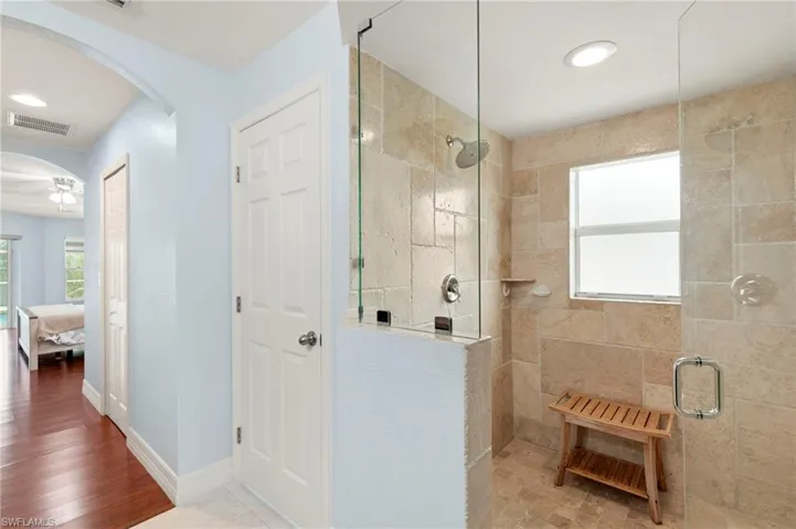 Full bath featuring tiled shower, connected bathroom, ceiling fan, recessed lighting, and wood finished floors