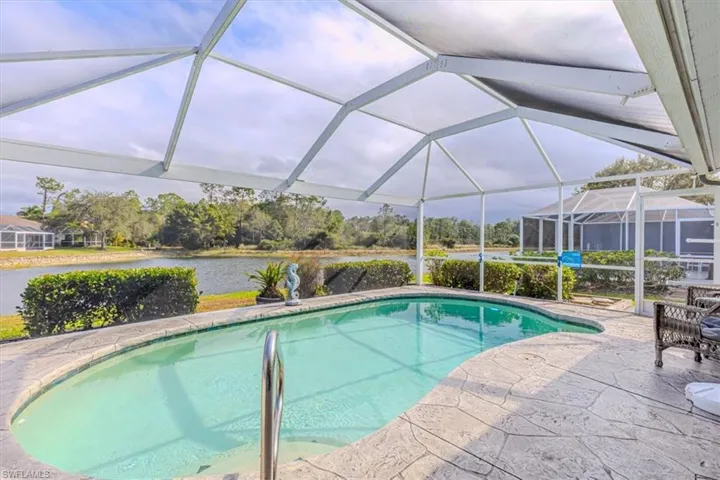 Outdoor pool area, w/ screen enclosure, & water view.