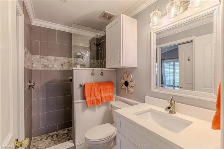 Guest Bathroom w/ walk in shower, vanity & ornamental molding.