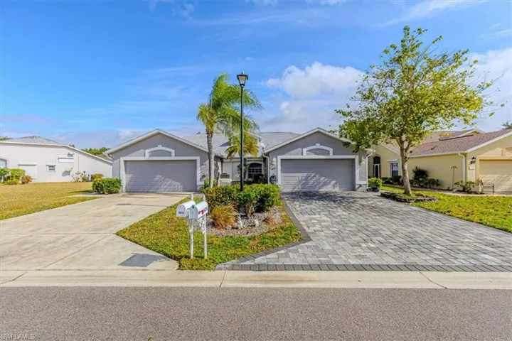 Single story home featuring decorative paver driveway, an attached 2 car garage, and a front yard.