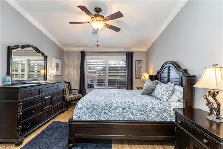 Primary Bedroom featuring ornamental molding, light wood-style flooring & ceiling fan.
