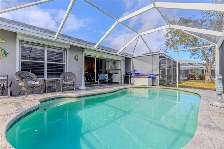 Outdoor pool area, w/ screen enclosure, & water view.