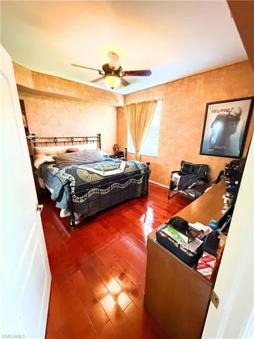 Bedroom with hardwood / wood-style floors and a ceiling fan