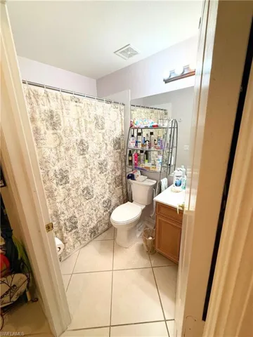 Full bath with vanity, tile patterned floors, and a shower with shower curtain