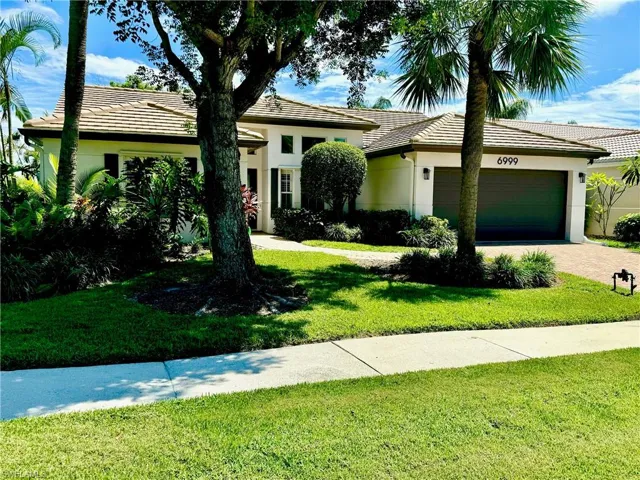 View of front facade featuring a garage and a front yard
