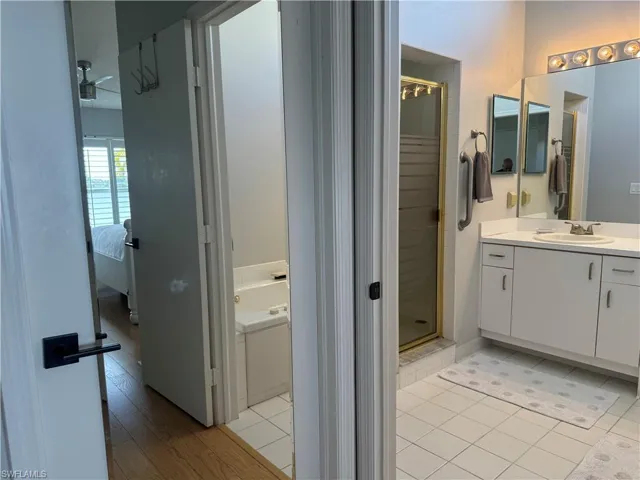 Bathroom with hardwood / wood-style floors, independent shower and bath, and vanity