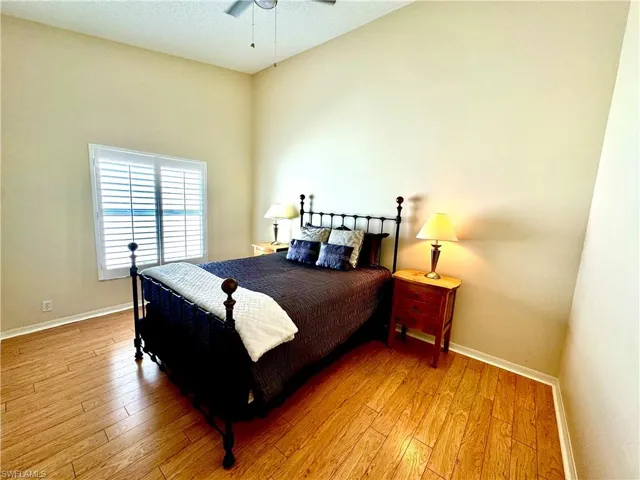 Bedroom with ceiling fan, a textured ceiling, and light hardwood / wood-style flooring