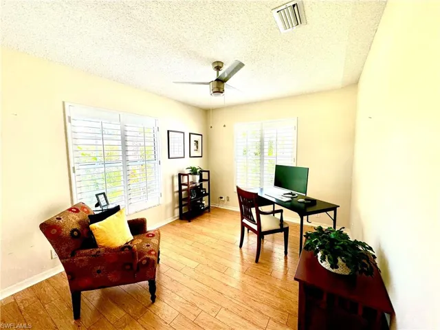 Office featuring ceiling fan, a textured ceiling, and light wood-type flooring
