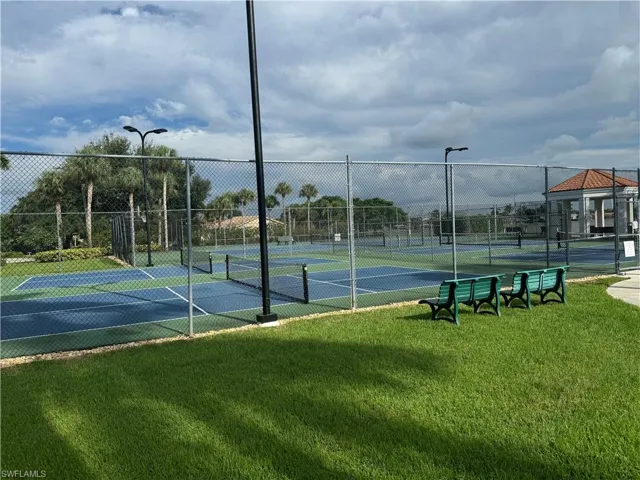 View of sport court with a lawn