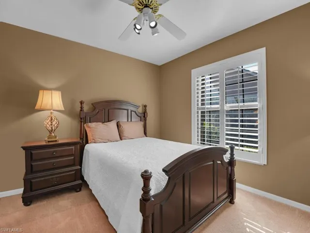 Bedroom with ceiling fan and light colored carpet