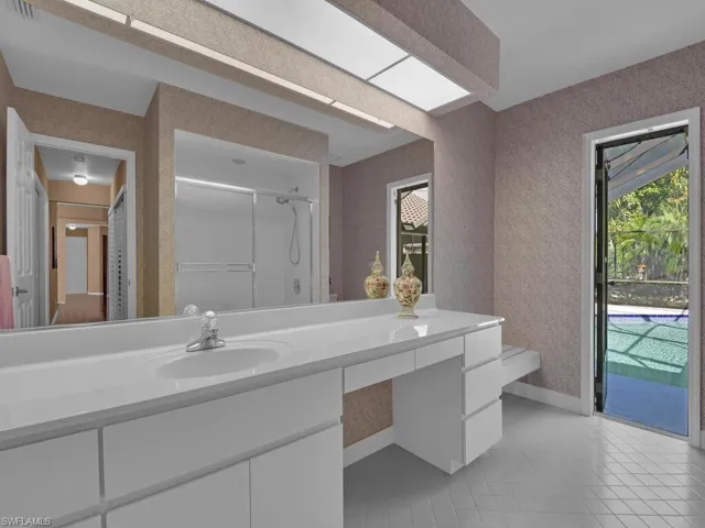 Bathroom with vanity, tile patterned floors, and walk in shower