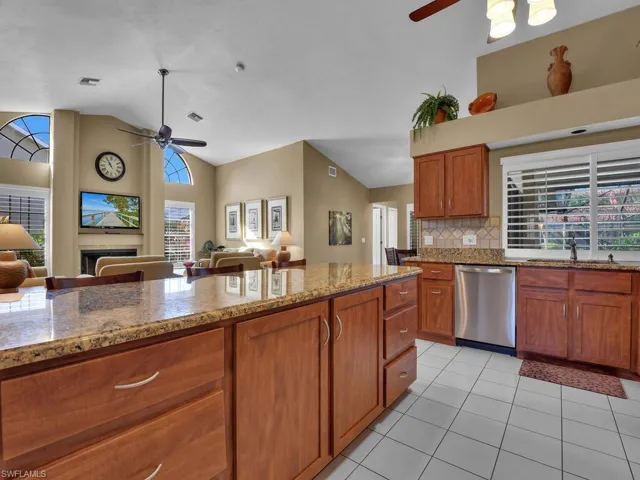Kitchen with ceiling fan, stainless steel dishwasher, decorative backsplash, and light tile patterned floors