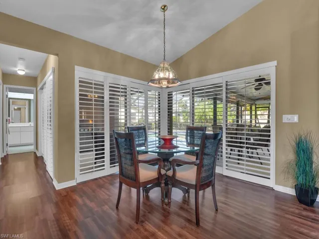 Dining room featuring vaulted ceiling and dark hardwood / wood-style flooring