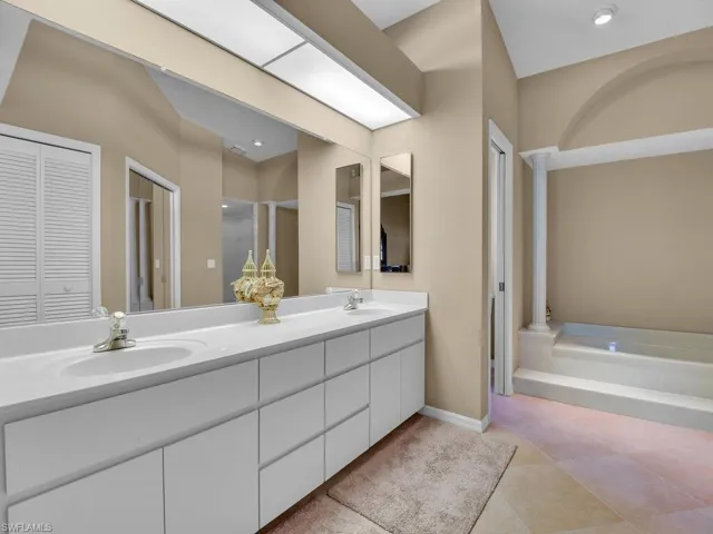 Bathroom featuring vanity, a bath, and decorative columns