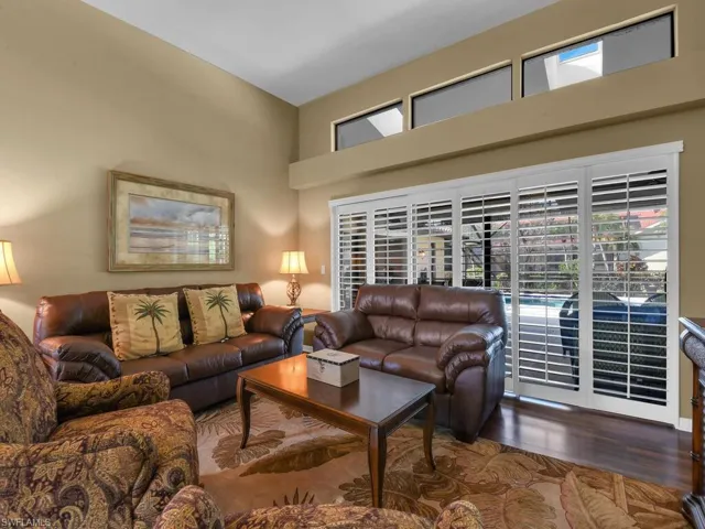 Living room with a towering ceiling and dark hardwood / wood-style floors