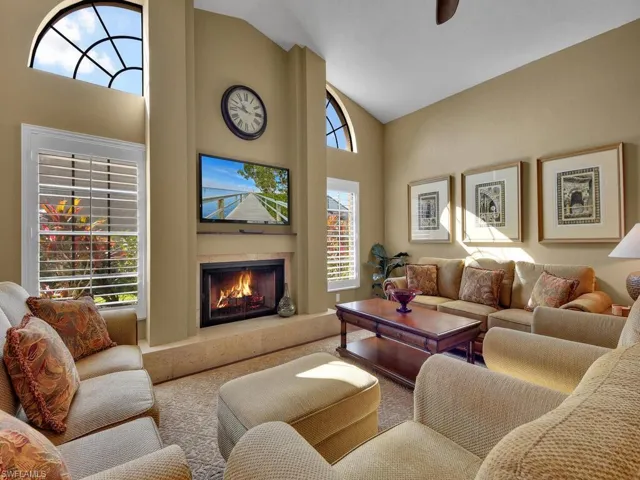 Living room with high vaulted ceiling and carpet flooring