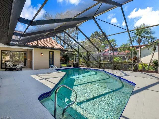 View of pool featuring a patio and glass enclosure