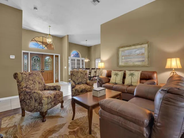 Living room with an inviting chandelier and a towering ceiling