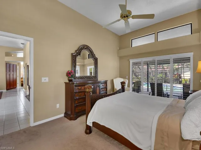 Bedroom with a high ceiling, access to outside, light carpet, and ceiling fan