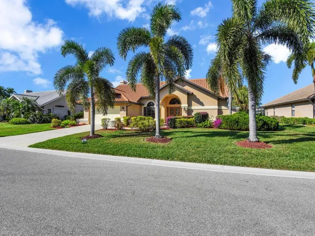 View of front facade featuring a garage and a front lawn
