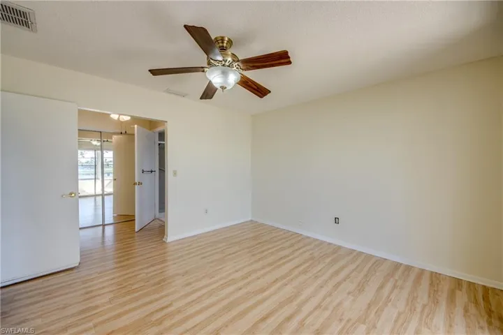 Empty room featuring ceiling fan, a textured ceiling, and light hardwood / wood-style floors