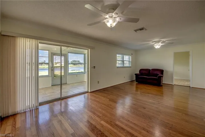 Unfurnished room featuring ceiling fan, hardwood / wood-style floors, ornamental molding, and a textured ceiling