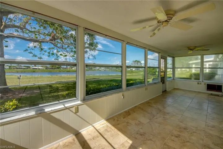 Unfurnished sunroom featuring a water view and ceiling fan