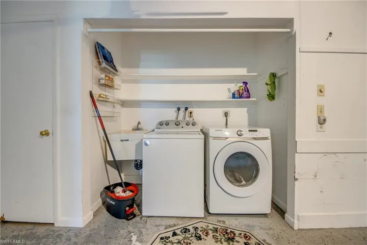 Laundry room featuring sink and washing machine and clothes dryer