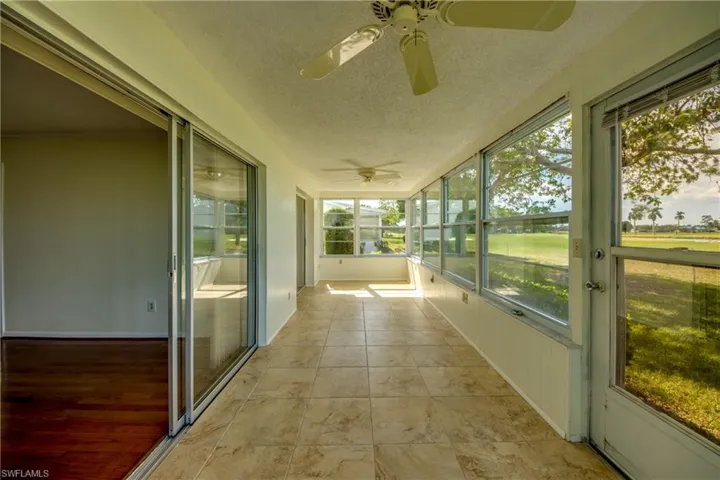 Unfurnished sunroom with ceiling fan