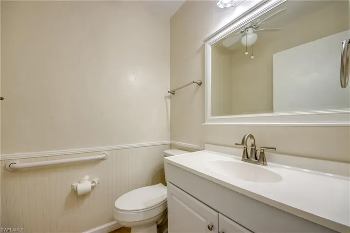Bathroom with ceiling fan, vanity, and toilet