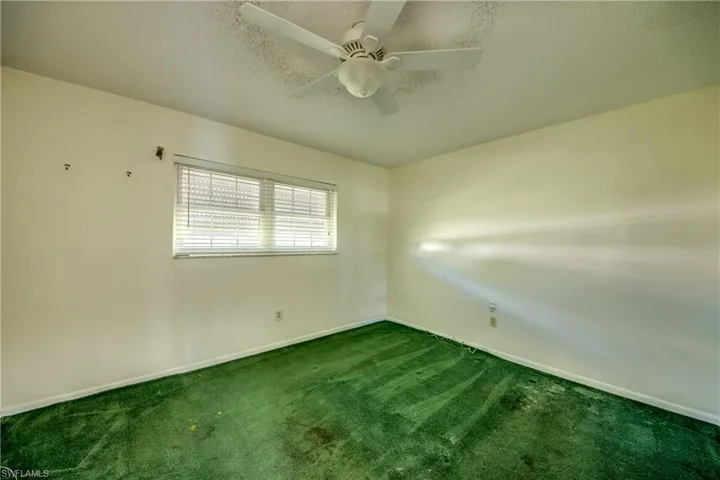 Carpeted spare room with a textured ceiling and ceiling fan