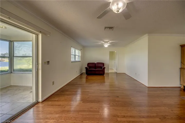 Unfurnished room with a textured ceiling, ornamental molding, hardwood / wood-style flooring, and ceiling fan
