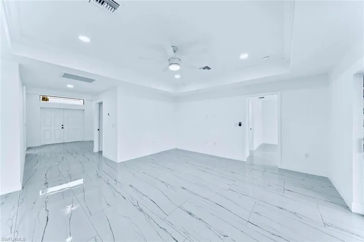 Unfurnished room featuring ceiling fan, a raised ceiling, and crown molding