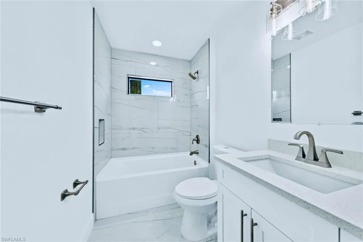 Full bathroom with vanity, toilet, and tiled shower / bath