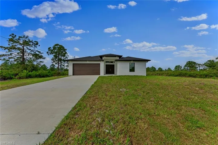 View of front of home featuring a front lawn and a garage