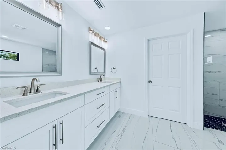 Bathroom featuring vanity and tiled shower