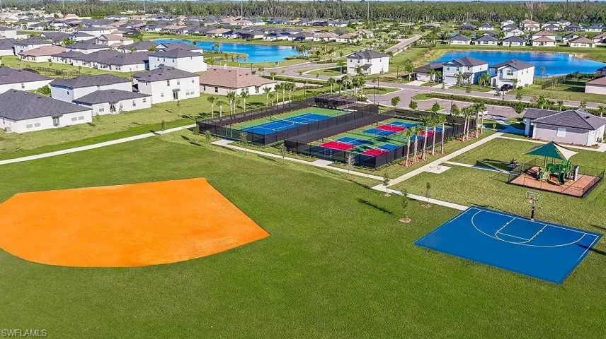 Community amenities featuring a baseball diamond, basketball court, fenced tennis courts, and a playground structure within a landscaped green space