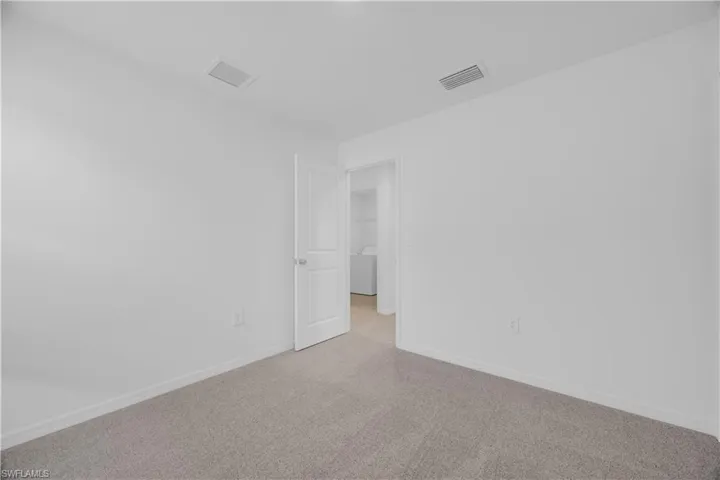 Neutral-toned carpet flooring with white baseboards and walls