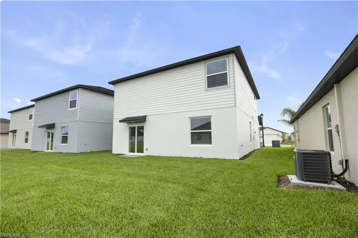 Newly constructed property featuring a spacious grass lawn