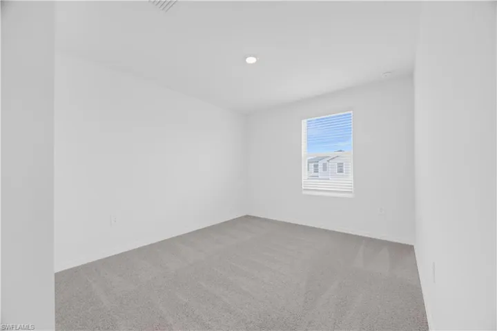 Room featuring light gray carpeting, white walls, a single window with horizontal blinds, and recessed lighting