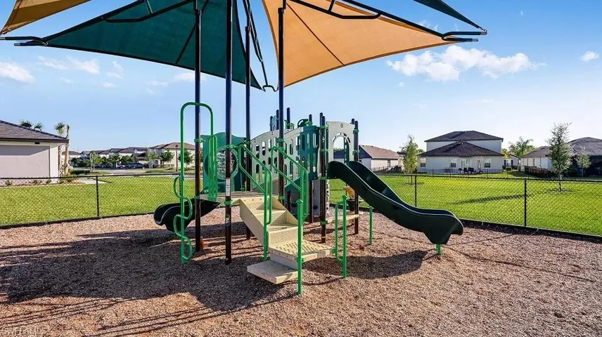 Outdoor recreation area featuring a multi-level play structure with slides and climbing elements