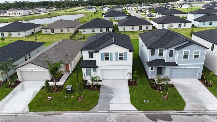 Modern two-story residence featuring a two-car garage, dark shingle roof, light blue siding, and a concrete driveway
