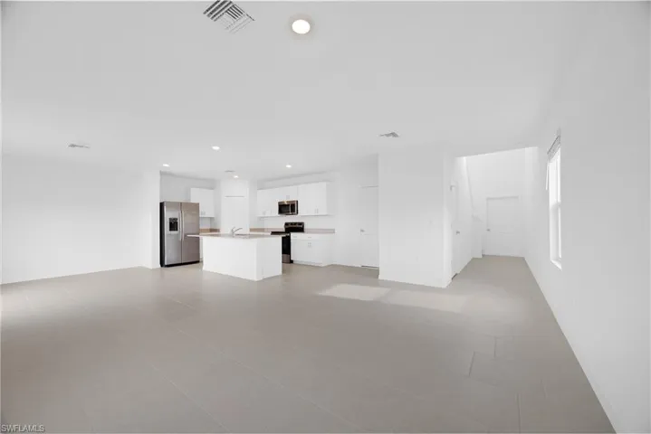 Open-concept living area with light-toned tile flooring throughout