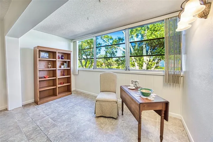 Living area featuring a textured ceiling and light tile patterned floors