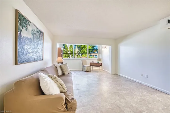 Living area with baseboards and a textured ceiling